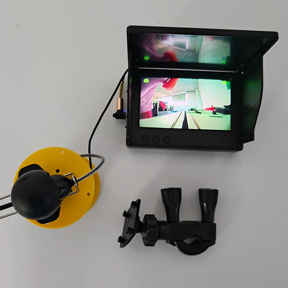 Fishing camera kit with its monitor powered on and cable reel beside it