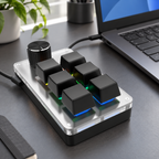 Schwarzes Makropad mit sechs Tasten per USB neben einem Laptop, illustrierte Schreibtischszene