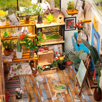 1:18 scale greenhouse garden model with rustic wooden flooring, easel and colorful flower details