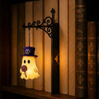 Geist mit Lutscher als Bücherregal-Leuchte an einer dunklen, dekorativen Halterung mit einem Lichtakzent vor den Buchrücken.