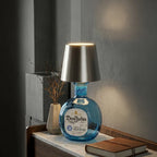 Tête de lampe BottleGlow argentée affichée sur une bouteille en verre bleu