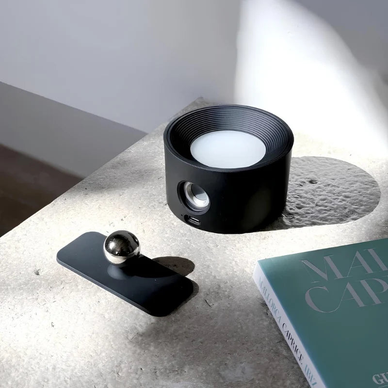 Applique ronde EasyStick noire détachée de sa base magnétique à rotule