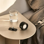 Tête de lumière EasyStick et base magnétique reposant séparément sur une table de chevet