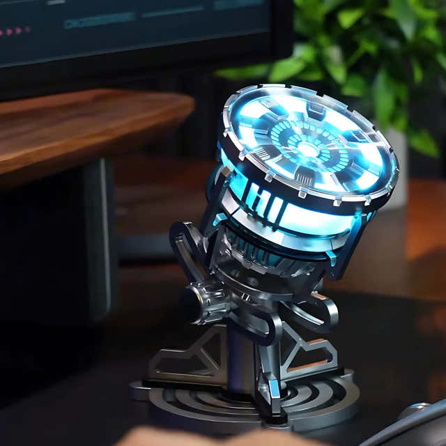Illuminated Iron Man MK3 arc reactor displayed on its stand beside a desk — Gearfinch