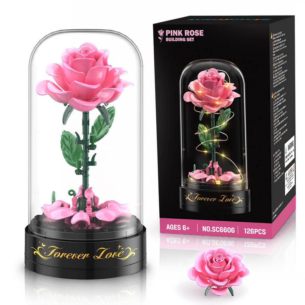 Rosa Rose aus Bausteinen mit transparenter Kuppel, schwarzer Spieluhr und Verpackung für 126 Teile.