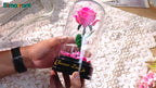 Hände halten die zusammengebaute Rose und drehen den Spieluhrsockel