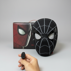 Black Ring Remote mask with moving eyes, wireless ring and product box on a grey background